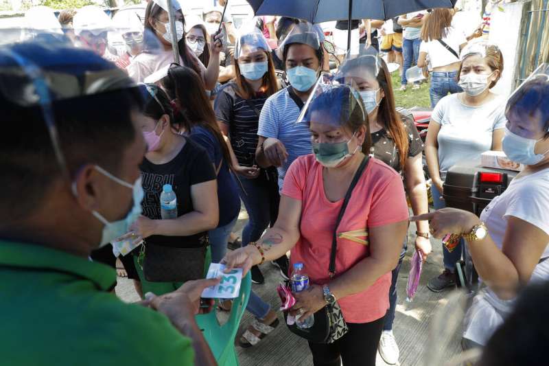 菲律賓的民眾正在排隊領取號碼牌，準備接種新冠疫苗。（美聯社）
