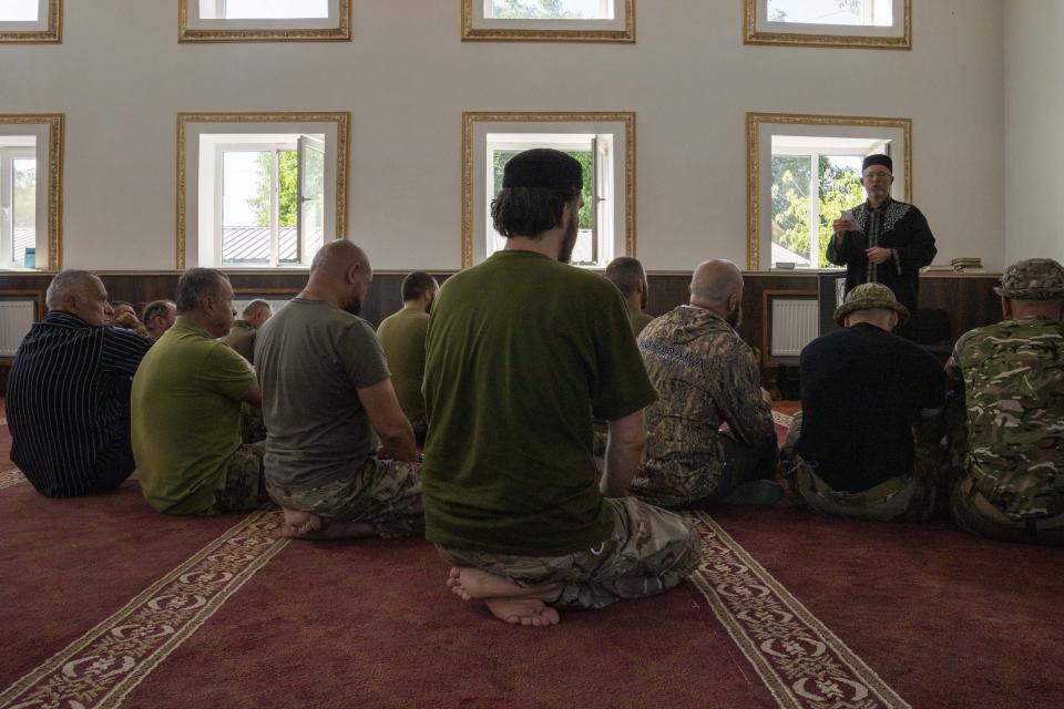 Former Mufti-turned-fighter Sheikh Said Ismahilov, right, leads Muslim soldiers during prayers on the first day of Eid al-Adha, in Medina Mosque, Konstantinovka, eastern Ukraine, Saturday, July 9, 2022. Muslims around the world celebrate Eid al-Adha by sacrificing animals to commemorate the prophet Ibrahim's faith in being willing to sacrifice his son. (AP Photo/Nariman El-Mofty)