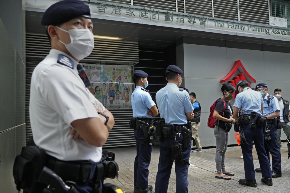 Chen Baoying, right with red backpack, one of the four protesters is searched by police officers during a protest against an election committee in Hong Kong Sunday, Sept. 19, 2021. Hong Kong's polls for an election committee that will vote for the city's leader kicked off Sunday amid heavy police presence, with chief executive Carrie Lam saying that it is "very meaningful" as it is the first election to take place following electoral reforms. (AP Photo/Vincent Yu)