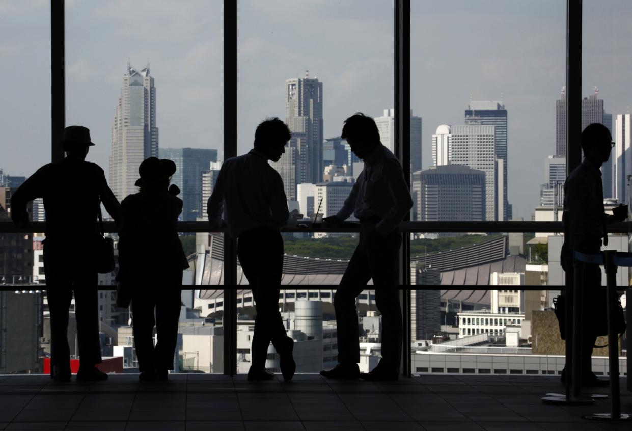 People stand at a window of an observation deck in Tokyo, Japan, on Monday, Sept. 28, 2015.  Photographer: Tomohiro Ohsumi/Bloomberg