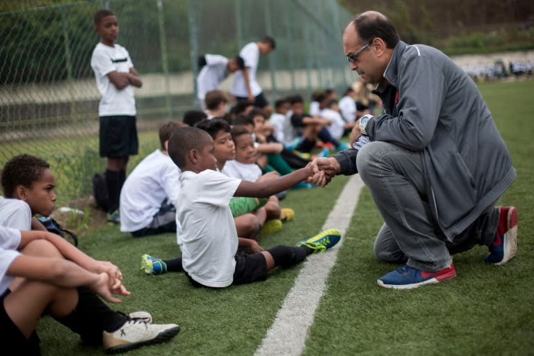 Scout Jorge Athayde (R) speaks to a boy during a trial in which youngsters play under the watch of scouts from one of Brazil's biggest football clubs, Vasco da Gama, in northern Rio de Janeiro