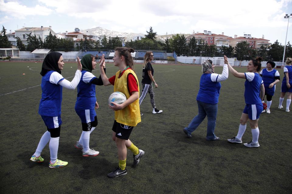 In this Thursday, May 2, 2019 photo, members of Hestia FC Women's Refugee Soccer and AO Vrilission players shake hands after a friendly game in Athens. Many of the players at Hestia FC weren't allowed to play or even watch soccer matches in their home countries. Hestia FC was set up by the Olympic Truce Centre, a non-government organization created in 2000 by the International Olympic Committee and Greek Foreign Ministry. (AP Photo/Thanassis Stavrakis)