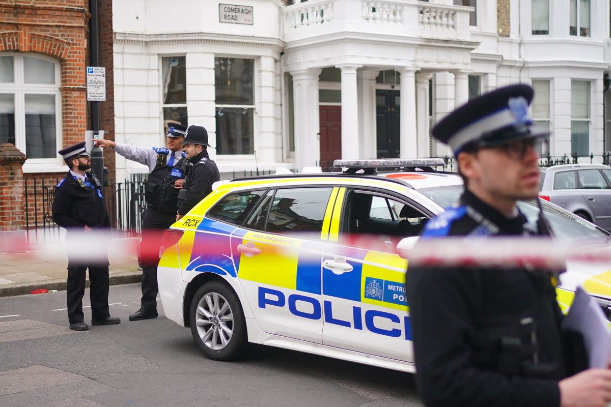 Police officers at the scene in Comeragh Road, West Kensington, after the shooting on Easter Monday (PA)