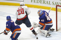 New York Islanders goaltender Semyon Varlamov (40) makes a save with Washington Capitals center Lars Eller (20) in front of the crease and Islanders defenseman Andy Greene (4) watching during the second period of an NHL hockey game Thursday, April 22, 2021, in Uniondale, N.Y. (AP Photo/Kathy Willens)