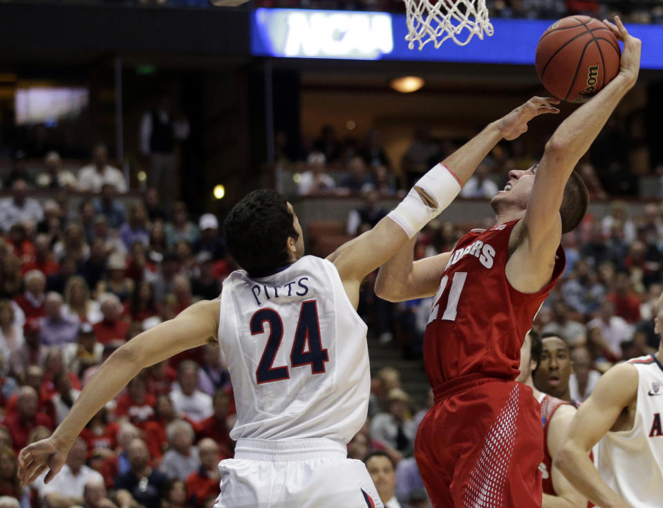 Wisconsin 's Josh Gasser (21) tries to shoot past Arizona's Elliott Pitts (24) during the first half in a regional final NCAA college basketball tournament game, Saturday, March 29, 2014, in Anaheim, Calif. (AP Photo/Jae C. Hong)