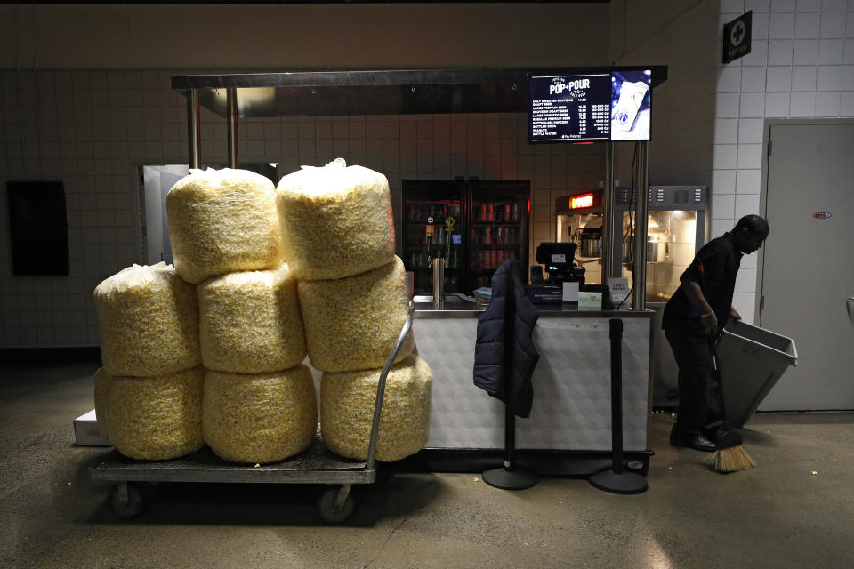 WASHINGTON, DC - MARCH 12: Bags of popcorn rest on a cart as a man cleans behind a vendor kiosk prior to the Detroit Red Wings playing against the Washington Capitals at Capital One Arena on March 12, 2020 in Washington, DC. Yesterday, the NBA suspended their season until further notice after a Utah Jazz player tested positive for the coronavirus (COVID-19). The NHL said per a release, that the uncertainty regarding next steps regarding the coronavirus, Clubs were advised not to conduct morning skates, practices or team meetings today. (Photo by Patrick Smith/Getty Images)