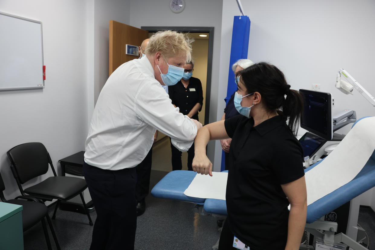 Britain's Prime Minister Boris Johnson, left, greets a member of staff, during a visit to Finchley Memorial Hospital, in North London, Tuesday, Jan. 18, 2022. (Ian Vogler, Pool Photo via AP)