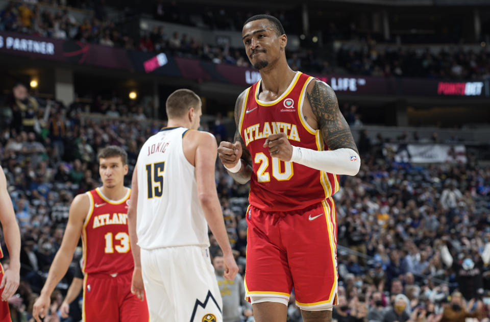 Atlanta Hawks forward John Collins, front, reacts after being called for a foul on Denver Nuggets center Nikola Jokic during the second half of an NBA basketball game Friday, Nov. 12, 2021, in Denver. (AP Photo/David Zalubowski)