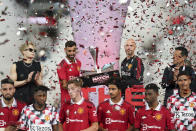 Manchester United Bruno Fernandes. second from left, and Manchester United's manager Erik ten Hag hold the trophy after winning their pre-season soccer match at the Rajamangala national stadium In Bangkok ,Thailand, Tuesday, July 12, 2022. Manchester United beat Liverpool's 4-0.(AP Photo/Wason Wanichakorn)