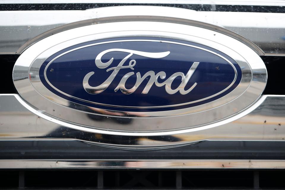 In this Oct. 20, 2019 file photograph, the company logo shines off the grille of an unsold vehicle at a Ford dealership in Littleton, Colo.