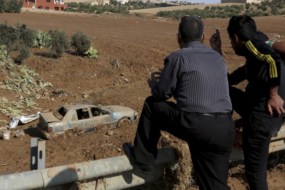 Jordanian rescue teams search Saturday, Nov. 10, 2018 for missing people in the Madaba area, south of the capital of Amman, after flash floods unleashed by heavy rain a day earlier killed at least 12 people. (AP Photo/Raad Adayleh)