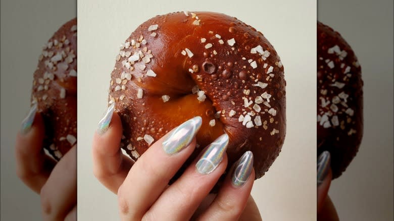 Hand holding pretzel bagel