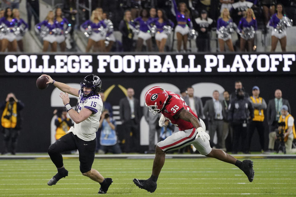 FILE - TCU quarterback Max Duggan (15) runs out of the pocket, chased by Georgia linebacker Robert Beal Jr. (33) during the second half of the national championship NCAA College Football Playoff game Jan. 9, 2023, in Inglewood, Calif. The conference commissioners who manage the College Football Playoff met Wednesday, Aug. 30, 2023, for the first time since a wave of realignment tore apart the Pac-12, raising the possibility that the number of automatic bids in the 12-team postseason format to be implemented next year could be tweaked. (AP Photo/Mark J. Terrill, File)