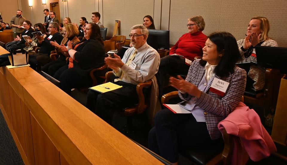 The juries for both schools, which were comprised of members of the community, applaud as the mock trials get underway at the federal courthouse Monday evening.