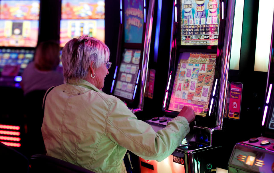 A woman plays at a slots arcade machine of Mecca Bingo, owned by the Rank Group