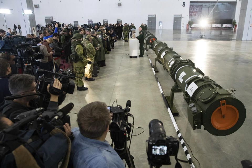 Foreign military attaches and journalists attend a briefing by the Russian Defense Ministry as the 9M729 land-based cruise missile, right, in Kubinka outside Moscow, Russia, Wednesday, Jan. 23, 2019. The Russian military on Wednesday rolled out its new missile and spelled out its specifications, seeking to dispel the U.S. claim that the weapon violates a key nuclear arms pact. (AP Photo/Pavel Golovkin)