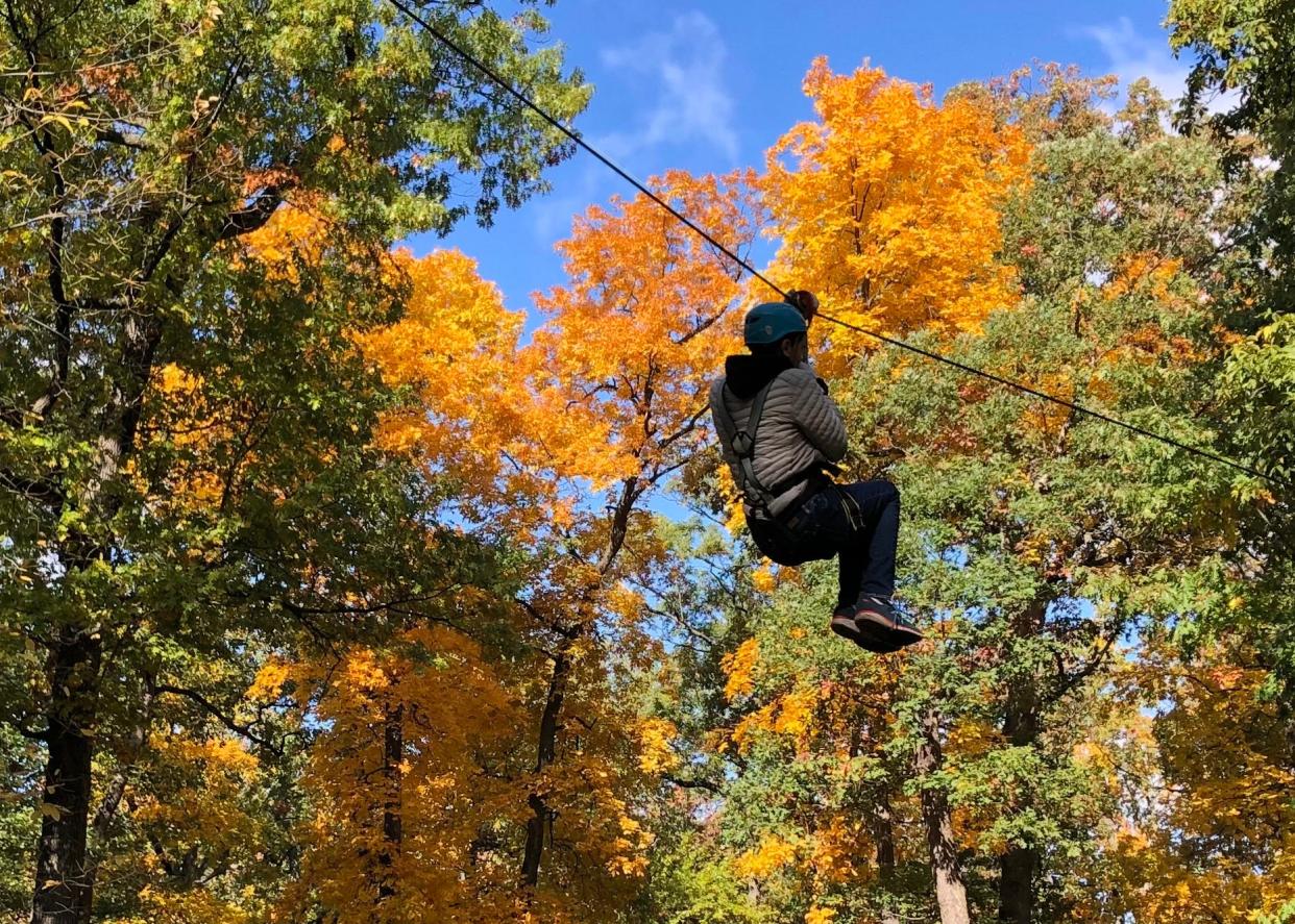 A climber descends on a zip line Oct. 15, 2022, at the Edge Adventure Park at South Bend's Rum Village Park.