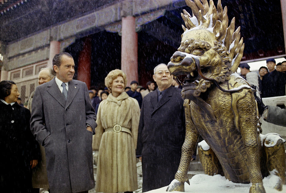 FILE - Then U.S. President Richard Nixon and then first lady Pat Nixon looks at a sculpture depicting a mythical beast on the palace grounds of Beijing's Forbidden City as heavy snow falls on Feb. 25, 1972. At the height of the Cold War, U.S. President Richard Nixon flew into communist China's center of power for a visit that over time would transform U.S.-China relations and China's position in the world in ways that were unimaginable at the time. (AP Photo, File)