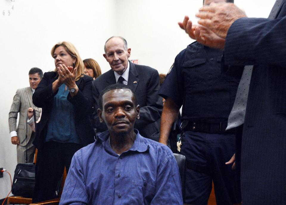 Henry McCollum sitting in court stunned as people applaud his exoneration