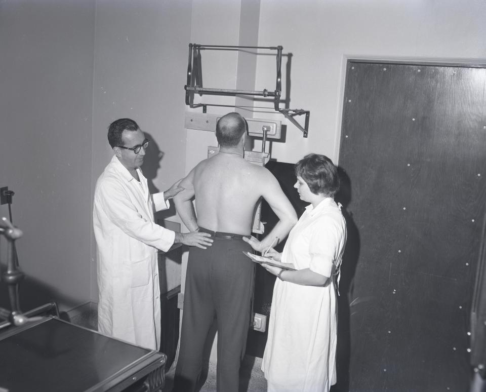 Dr. Raymond Evers (left) does a chest x-ray at a free Rocky Knoll clinic in December 1960.