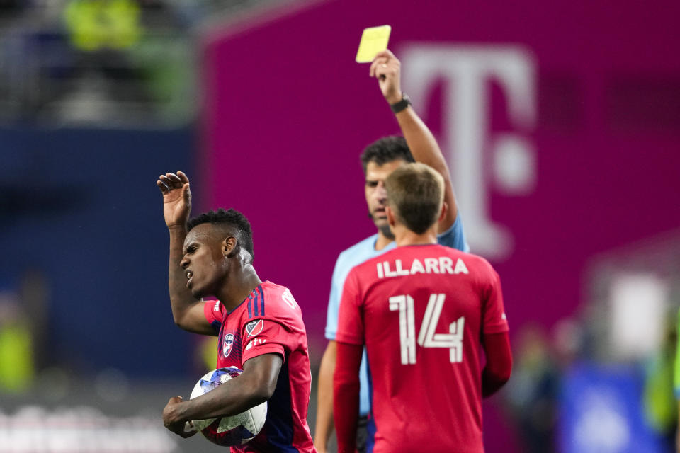 FC Dallas forward Jáder Obrian, left, holds the ball after being given a yellow card for a foul against Seattle Sounders midfielder João Paulo (not shown) during the first half of Game 3 of a first-round playoff MLS soccer match Friday, Nov. 10, 2023, in Seattle. (AP Photo/Lindsey Wasson)