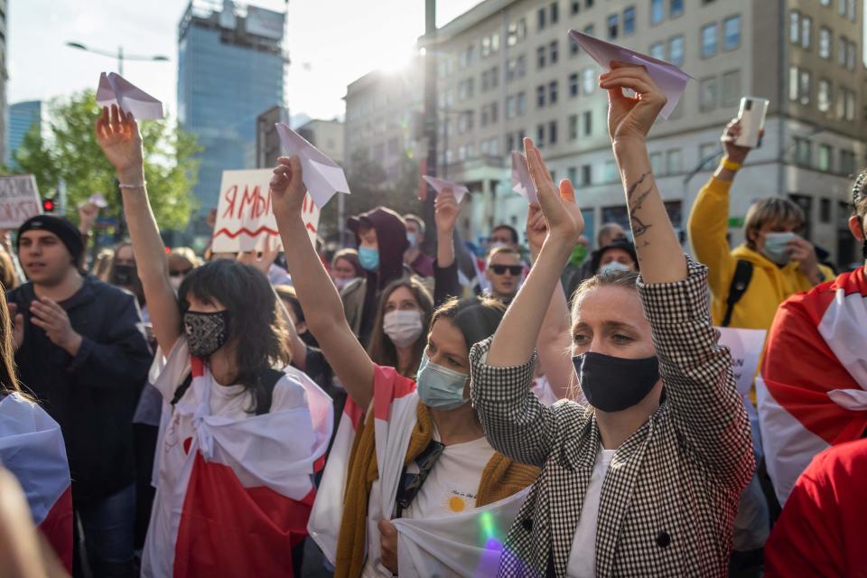 Belarusians living in Poland and Poles supporting them hold up paper planes during a demonstration in front of the European Commission office in Warsaw on May 24, 2021, demanding freedom for Belarus opposition activist Roman Protasevich.