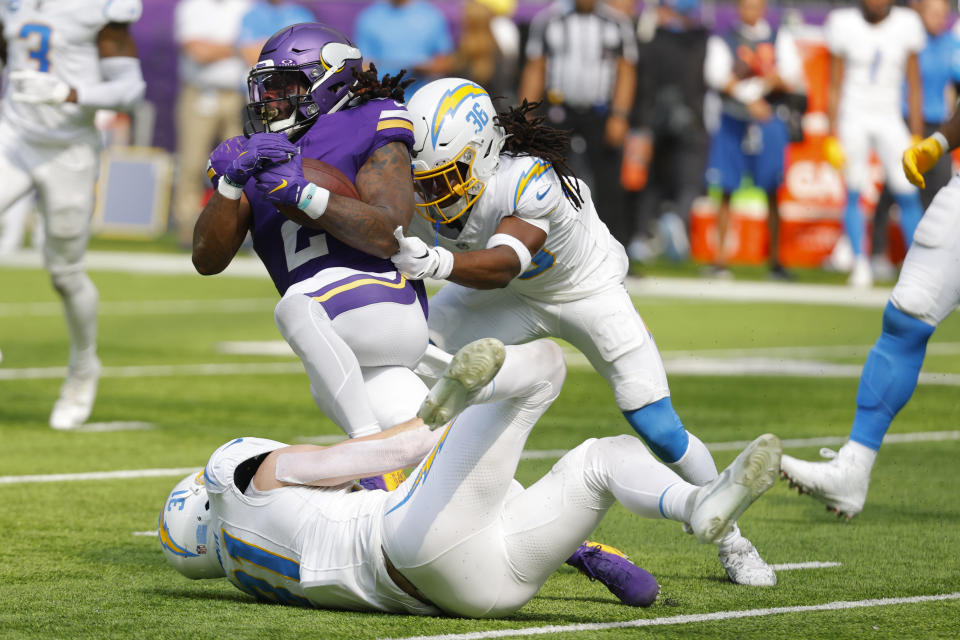 Minnesota Vikings running back Alexander Mattison (2) is tackled by Los Angeles Chargers linebacker Nick Niemann (31) and cornerback Ja'Sir Taylor (36) during the first half of an NFL football game, Sunday, Sept. 24, 2023, in Minneapolis. (AP Photo/Bruce Kluckhohn)