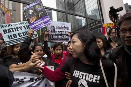 Erwiana Sulistyaningsih (C), a former Indonesian domestic helper, is greeted by her supporters outside a district court in Hong Kong February 27, 2015. REUTERS/Tyrone Siu