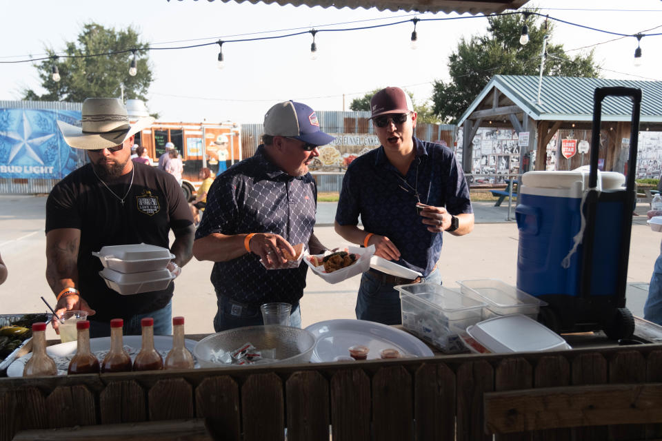 A group of calf fry enthusiasts grab their condiments Saturday evening at the 1st annual Calf Fry Festival at the Starlight Ranch Event Center in Amarillo.