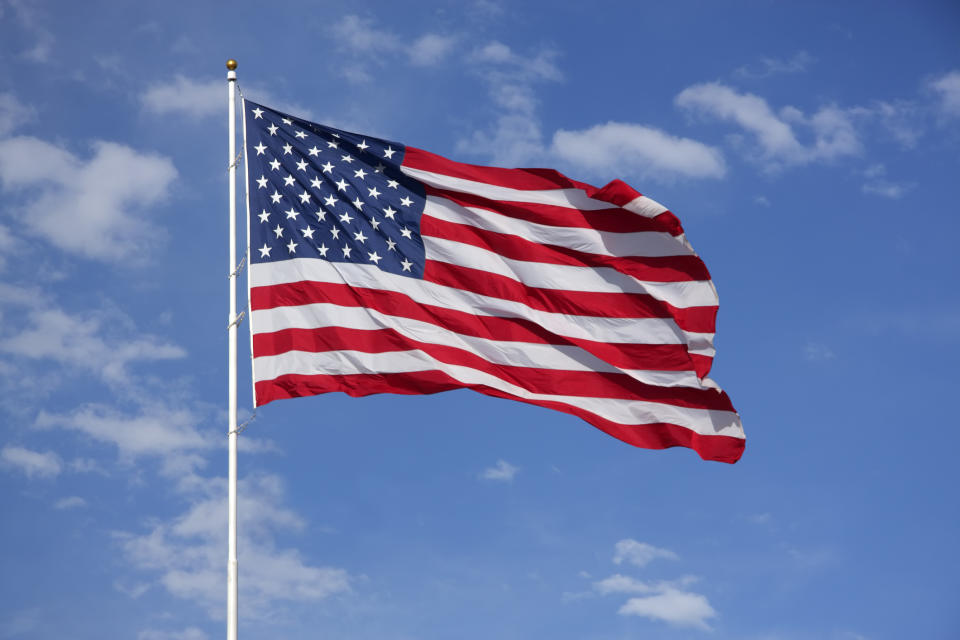 American flag waving against a partly cloudy sky