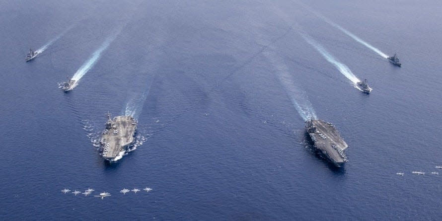 Aircraft from Carrier Air Wing 5 and Carrier Air Wing 17 fly in formation over the Nimitz Carrier Strike Force (CSF). The USS Nimitz (CVN 68) and USS Ronald Reagan (CVN 76) Carrier Strike Groups are conducting dual carrier operations in the Indo-Pacific as the Nimitz CSF.