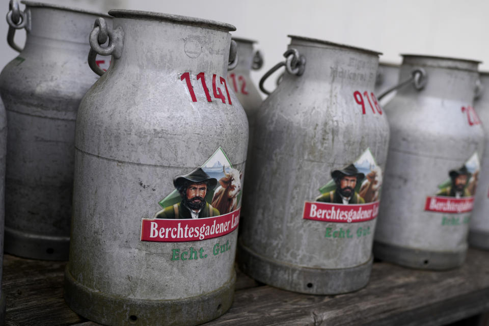 Old milk cans of the Berchtesgadener Land dairy cooperative stand at the main entrance in Piding near Munich, Germany, Friday, July 15, 2022. The Molkerei Berchtesgadener Land has stockpiled 200,000 liters of fuel oil so it can continue to produce electricity and steam if natural gas supplies to its turbine generator are cut off. (AP Photo/Matthias Schrader)