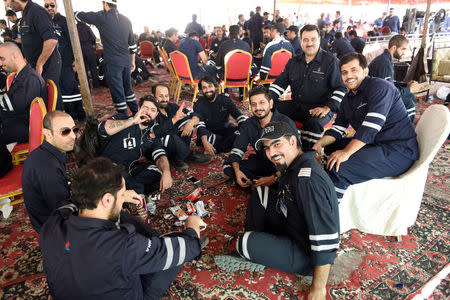 Kuwaiti oil sector employees sit in a shaded area on the first day of an official strike called by the Oil and Petrochemical Industries Workers Union over public sector pay reforms, in Ahmadi, Kuwait April 17, 2016. REUTERS/Stephanie McGehee/File Photo