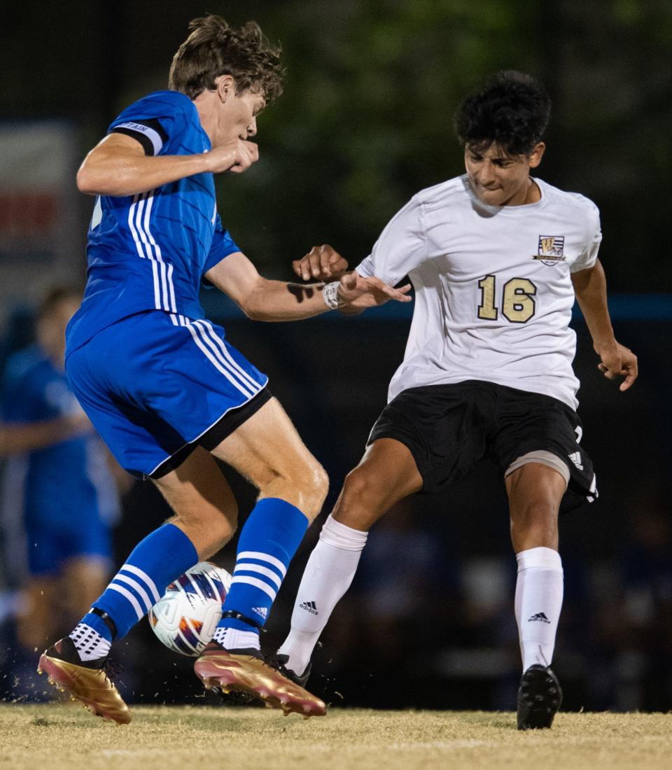 Memorial’s Brayden Wynn (11) is defended by Washington’s Jairo Dubon (16) as the Memorial Tigers play the Washington Hatchets at Memorial High School in Evansville, Ind., Wednesday evening, Oct. 12, 2022. 