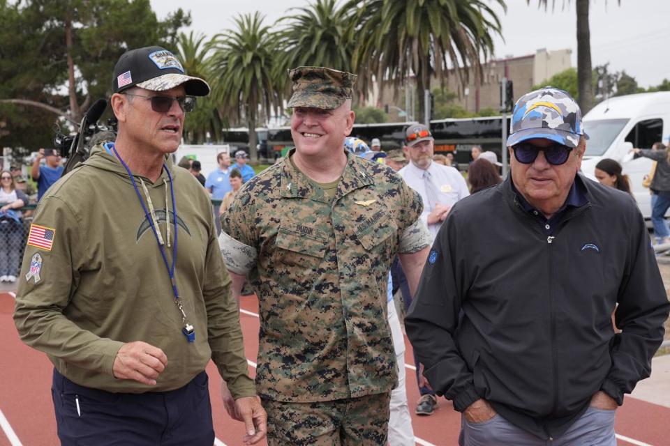 Chargers coach Jim Harbaugh (left) and owner Dean Spanos flank Marine Colonel Charles Dudik.