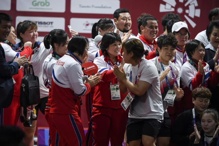 North and South Korean weightlifters congratulate each other and pose for photos together at the Asian Games in Jakarta on Monday