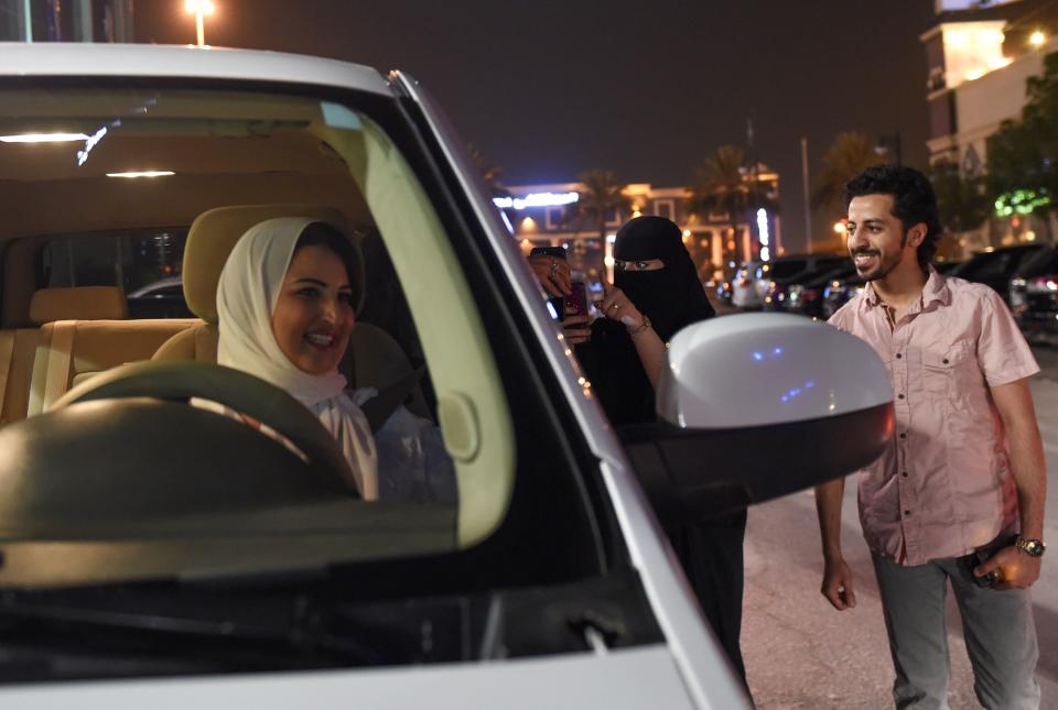 A Saudi woman films and shows support to Samar Almogren (left), who drives her car through the streets of the Saudi capital Riyadh for the first time just after midnight, June 24, 2018, when the law allowing women to drive took effect. (Photo: FAYEZ NURELDINE via Getty Images)