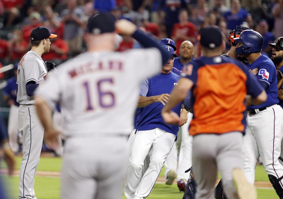 Carlos Gomez (far right) goes after Astros pitcher Collin McHugh during Monday's game. (Getty Images)