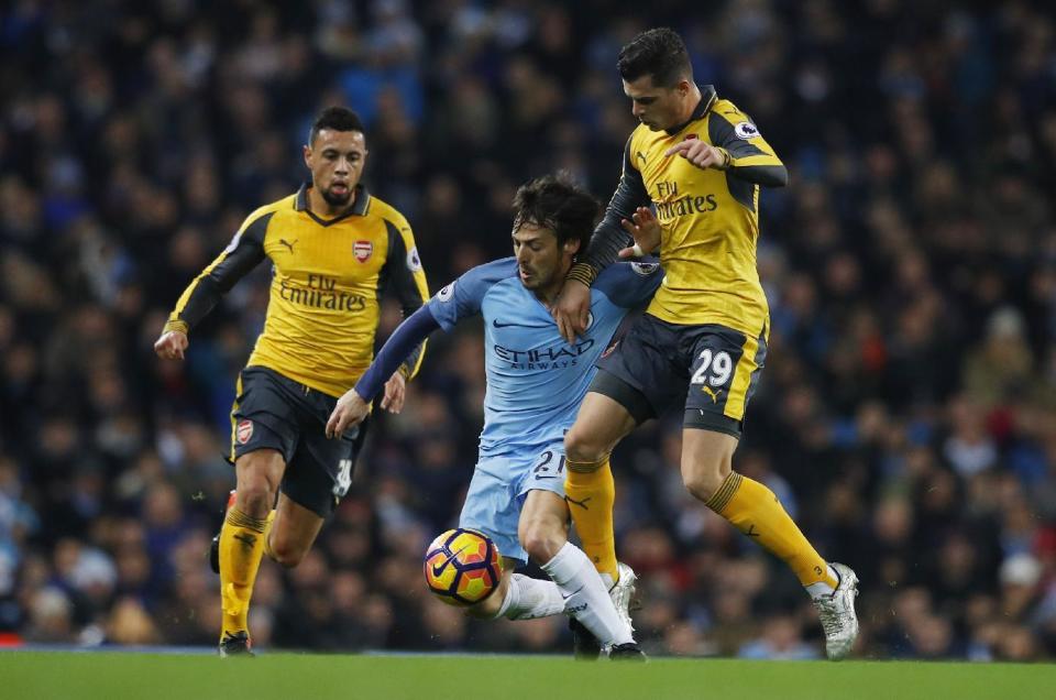 <p>Britain Football Soccer – Manchester City v Arsenal – Premier League – Etihad Stadium – 18/12/16 Manchester City’s David Silva in action with Arsenal’s Granit Xhaka and Francis Coquelin Reuters / Phil Noble Livepic EDITORIAL USE ONLY. No use with unauthorized audio, video, data, fixture lists, club/league logos or “live” services. Online in-match use limited to 45 images, no video emulation. No use in betting, games or single club/league/player publications. Please contact your account representative for further details. </p>