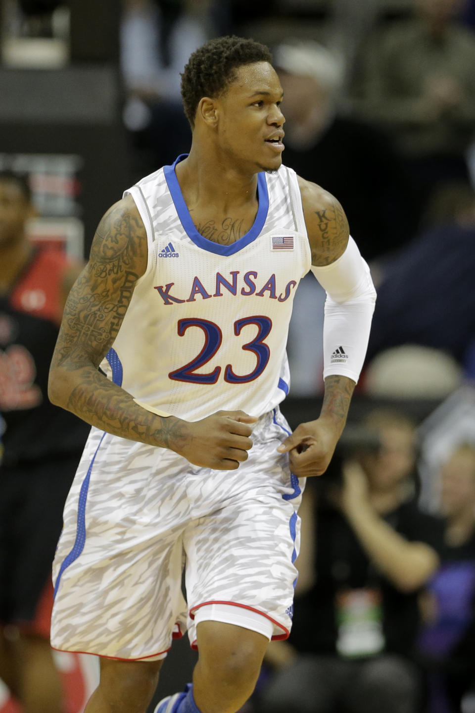 FILE - This March 14, 2013 file photo shows Kansas guard Ben McLemore during the first half an NCAA college basketball game against Texas Tech in the Big 12 men's tournament in Kansas City, Mo. The neon-colored jerseys and camouflage-covered shorts debuted by six teams in their post-season conference championships ahead of the NCAA men's basketball tournament weren't well received in the press and social media. The changes happened to be in line with fashion runways and in recreational athleticwear, where highlighter brights and creative camo have been bona fide trends, and alternate uniforms have become part of the college football and basketball landscape, but on the court, these uniforms still made fans cringe. (AP Photo/Charlie Riedel, file)