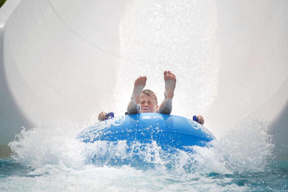 <p>Cameron Blake splashes into the pool on the waterslide at Bousquet Mountain in Pittsfield, Mass., Friday, June 30, 2017. (Photo: Stephanie Zollshan/The Berkshire Eagle via AP) </p>