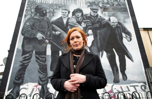 Julieann Campbell, the niece of Bloody Sunday victim Jackie Duddy, poses for a photograph by a mural depicting the late Bishop Edward Daly waving a white handkerchief as Jackie Duddy is carried away during the 1972 Bloody Sunday killings