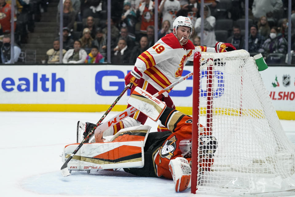 Calgary Flames' Matthew Tkachuk, top, skates past Anaheim Ducks goaltender John Gibson after scoring a shootout goal in an NHL hockey game Friday, Dec. 3, 2021, in Anaheim, Calif. The Flames won 4-3. (AP Photo/Jae C. Hong)