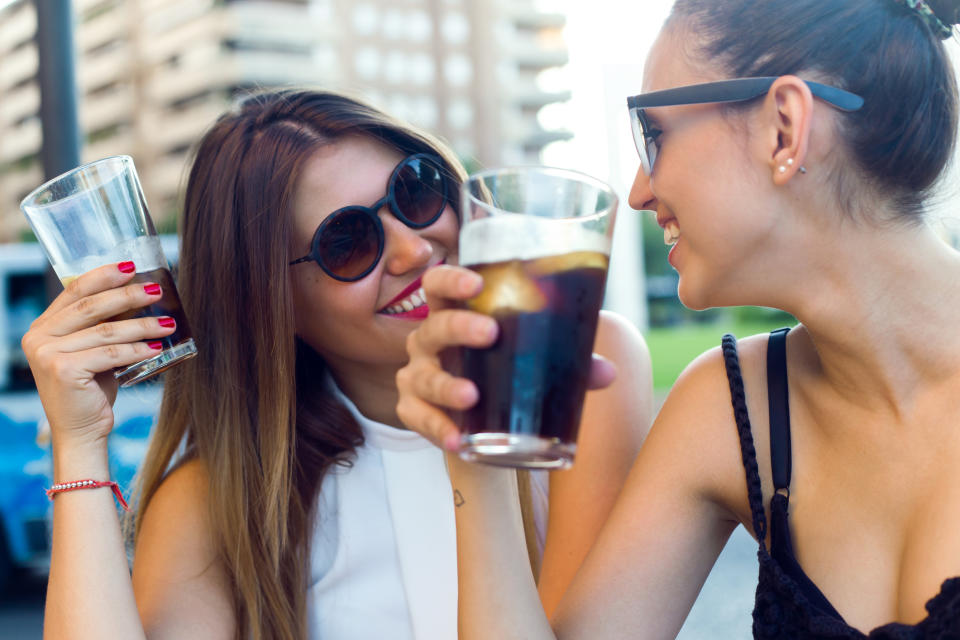 Two women enjoying sodas.