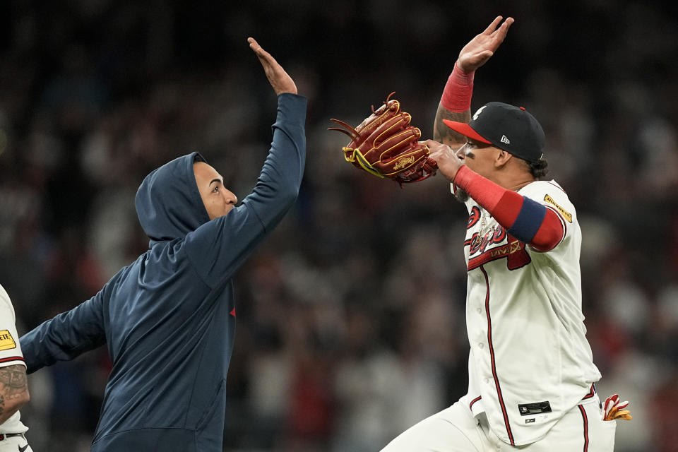 Atlanta Braves' Orlando Arcia, right, celebrates a win with Eddie Rosario after Game 2 of a baseball NL Division Series against the Philadelphia Phillies, Monday, Oct. 9, 2023, in Atlanta. The Atlanta Braves won 5-4. (AP Photo/Brynn Anderson)