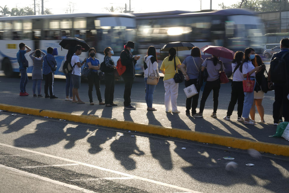 Passengers wait for a ride during morning rush hour as passenger jeepney groups hold a transport strike in Quezon city, Philippines on Monday, March 6, 2023. Philippine transport groups launched a nationwide strike Monday to protest a government program drivers fear would phase out traditional jeepneys, which have become a cultural icon, and other aging public transport vehicles. (AP Photo/Aaron Favila)