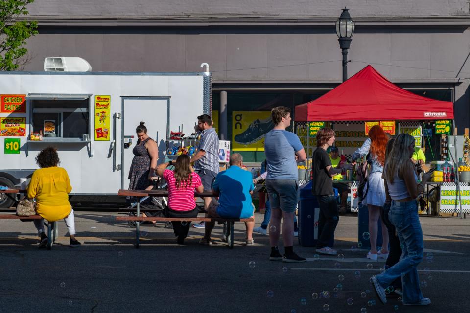 Attendees stroll down Main Street during Tri-Fest in Henderson, Ky., Friday afternoon, April 14, 2023.