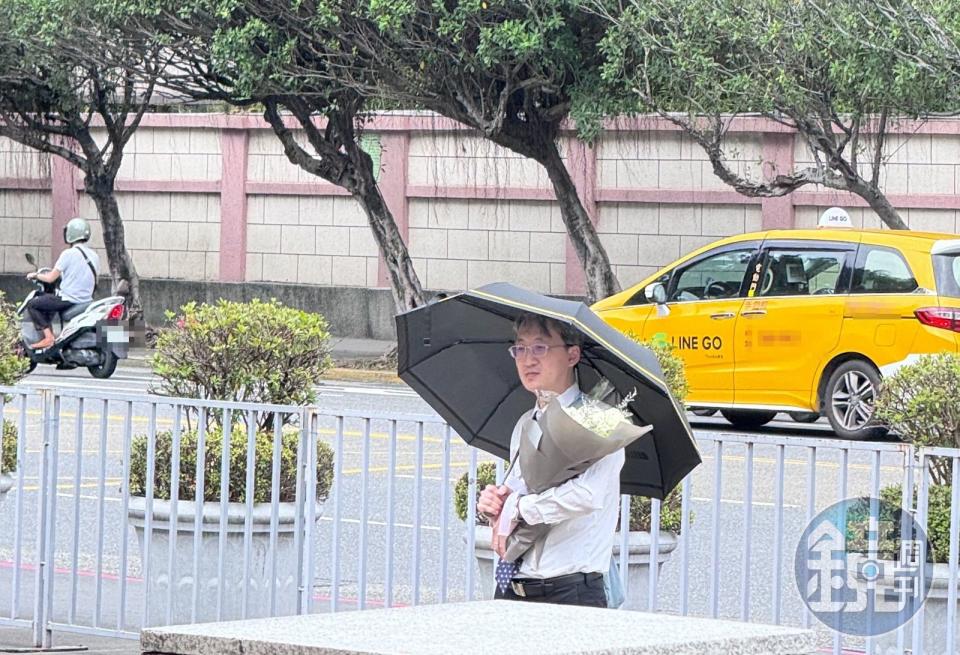 基隆地院法官李岳今現身司法院正門口，手捧白花、撐著黑傘，預計他將會在這站上一天。（本刊資料照）