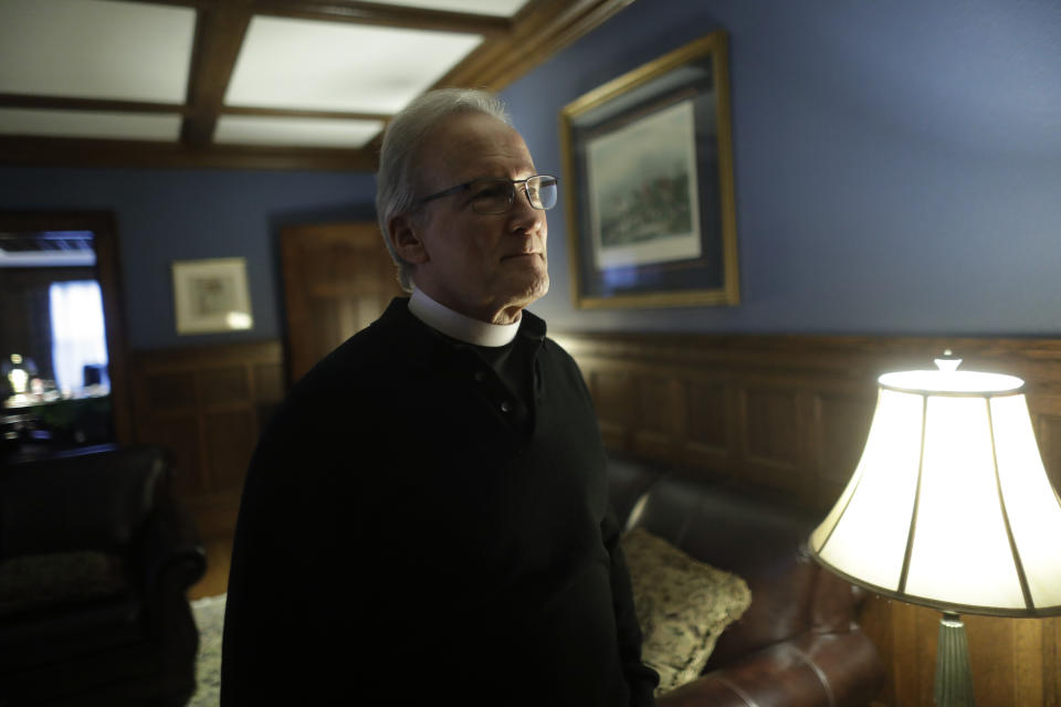 In this Sunday, Oct. 20, 2019 photo Rev. William Tourigny, center, pastor of St. Rose de Lima Parish, in Chicopee, Mass., speaks with a reporter from The Associated Press at the Catholic church's rectory. When Tourigny, 66, was ordained in 1980, the Springfield diocese had more than 300 priests serving 136 parishes. Since then, the ranks of priests have shrunk by more than half and nearly 60 of the parishes have closed. For Tourigny, it's meant many more funerals to handle, including dozens related to drug overdoses and heavy drinking. (AP Photo/Steven Senne)