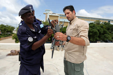 Drone instructor Brett Velicovich (R) holds a DJI Mavic pro drone as he cunducts a drone training session for Somali police officers in Mogadishu, Somalia May 25, 2017. Picture taken May 25, 2017. REUTERS/Feisal Omar